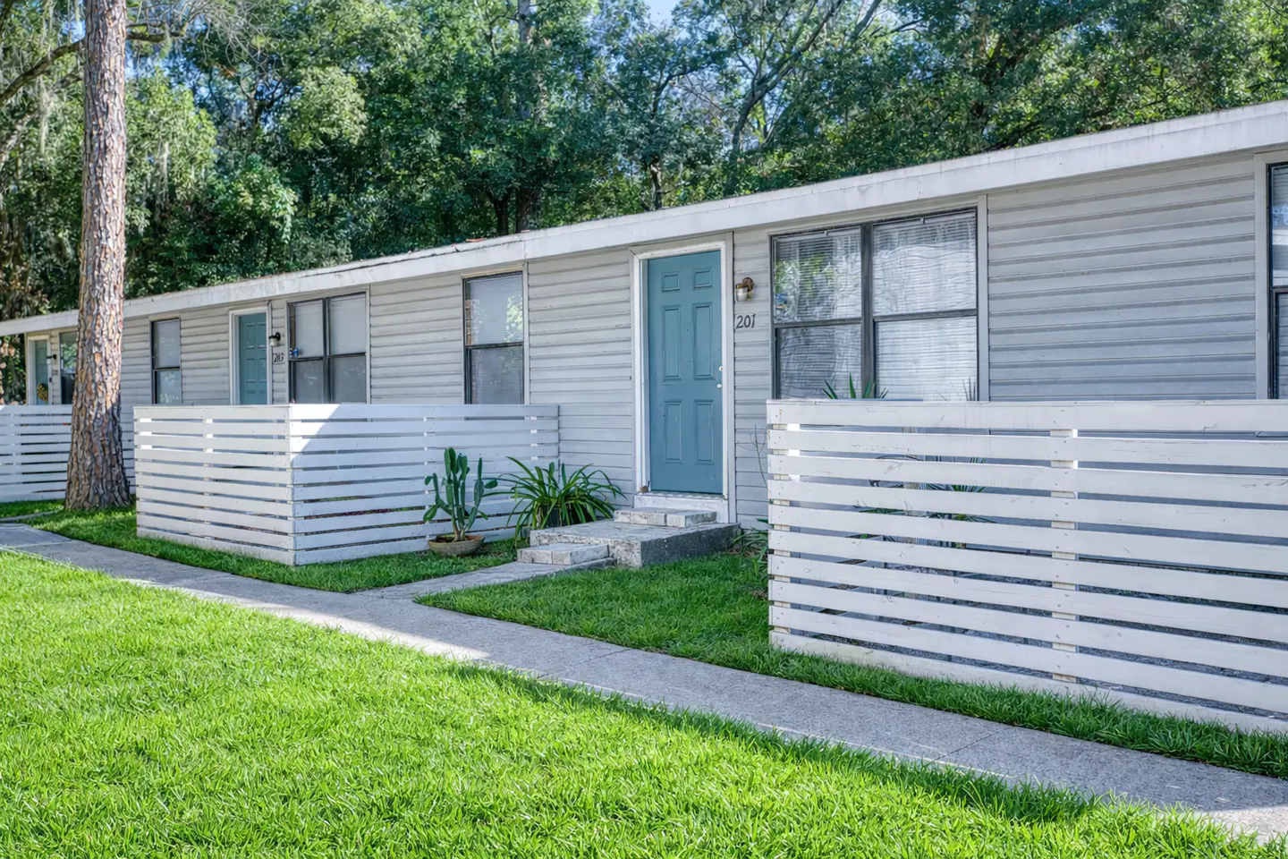 Single-story apartment buildings and landscaped grounds at Vintage Grove Apartments in Jacksonville, Florida.